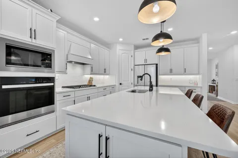 a view of a kitchen with kitchen island a sink stainless steel appliances and cabinets