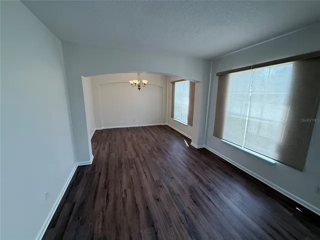 a view of a room with wooden floor and a ceiling fan