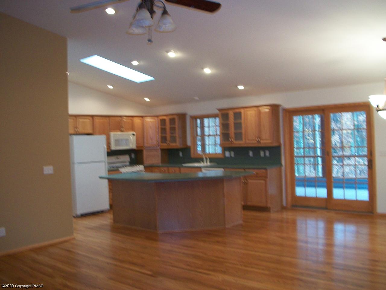 106 Rodeo Drive Hawley, PA 18428 - Photo 2 of 3 a large kitchen with stainless steel appliances granite countertop a large counter top a sink and a wooden floors