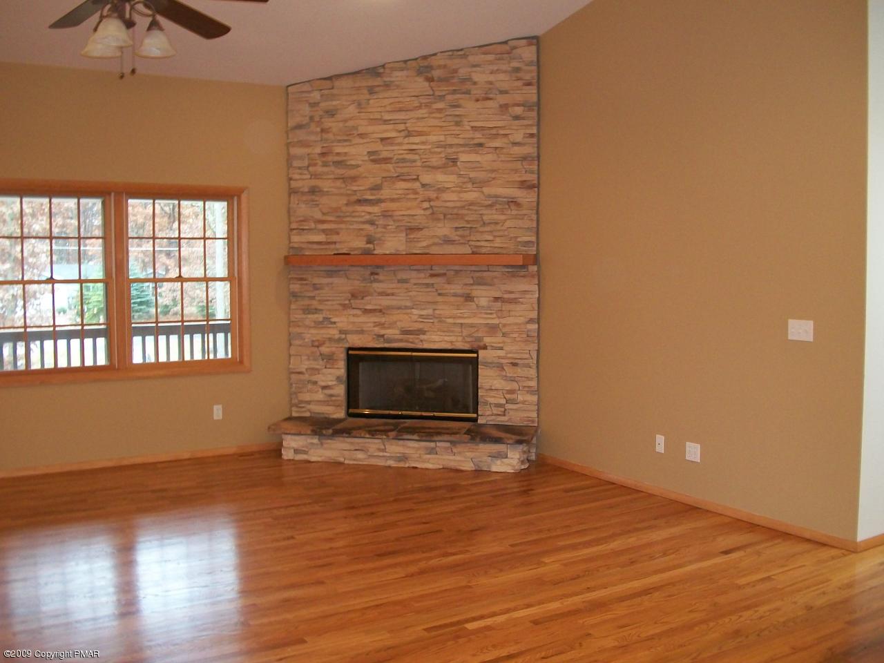 106 Rodeo Drive Hawley, PA 18428 - Photo 3 of 3 a view of empty room with wooden floor and fireplace