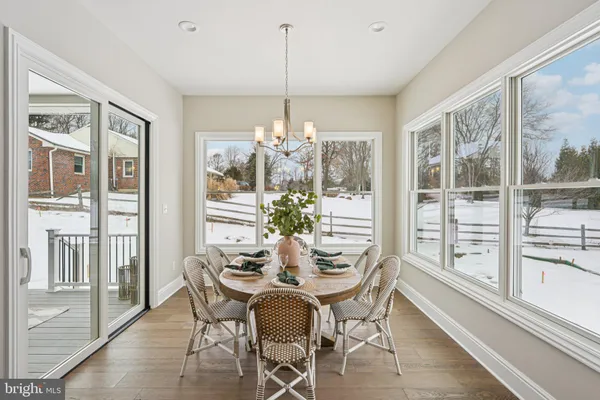 a dining room with furniture a chandelier and wooden floor