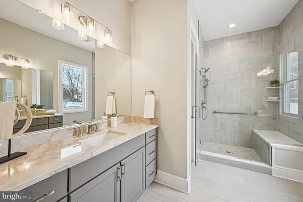 a bathroom with a sink double vanity granite tub shower and mirror
