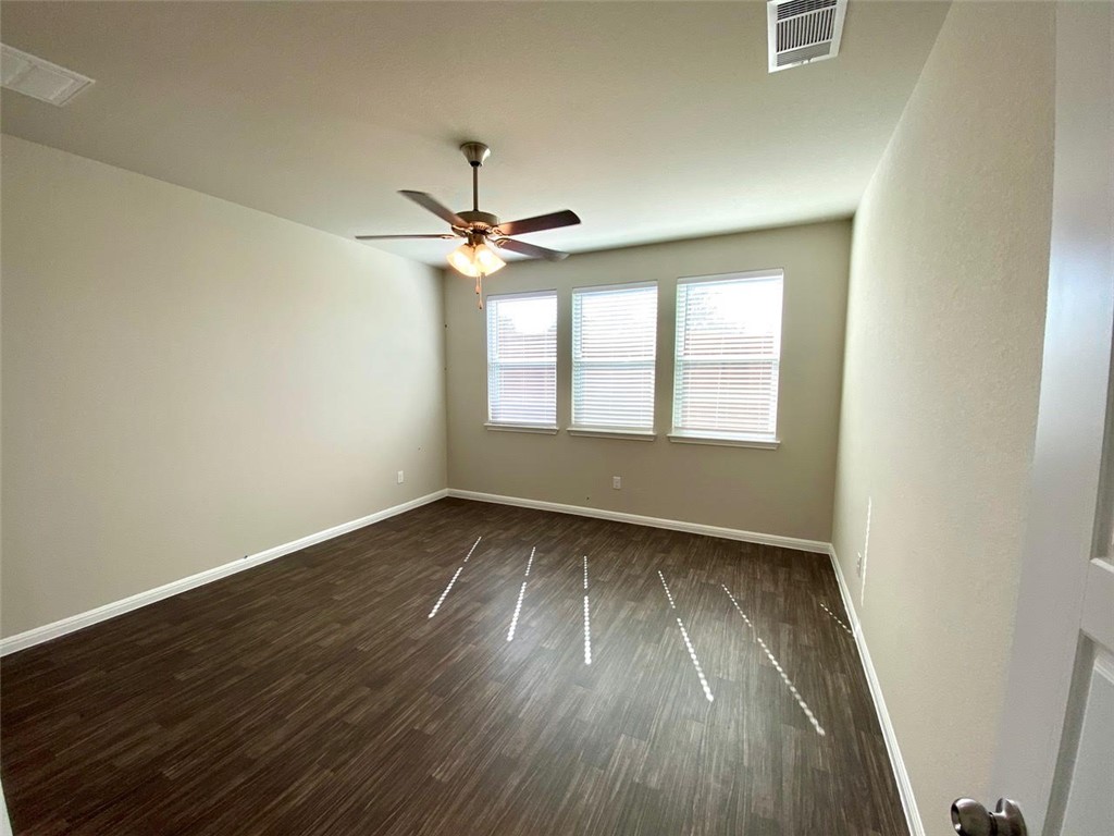 237 Michaelis Drive Leander, TX 78641 - Photo 14 of 23 an empty room with wooden floor fan and windows
