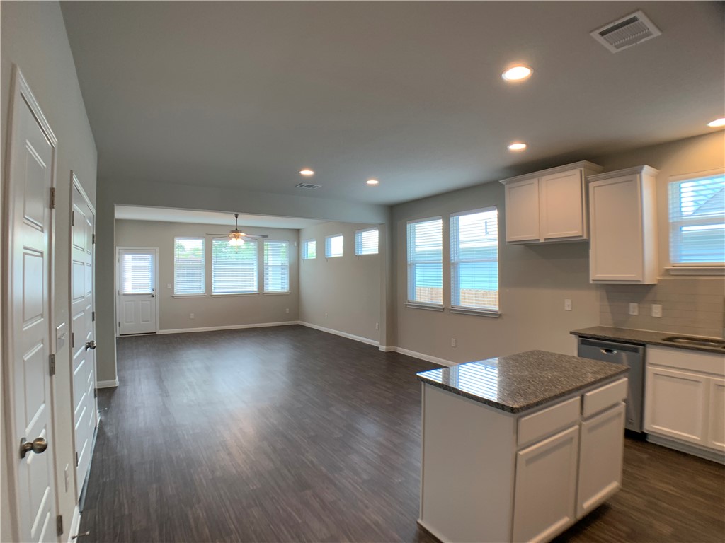 237 Michaelis Drive Leander, TX 78641 - Photo 4 of 23 an open kitchen with kitchen island wooden floors and stainless steel appliances