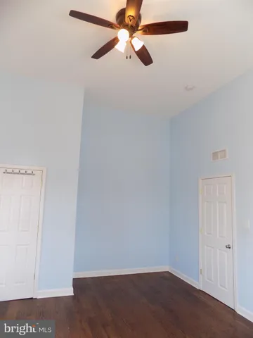 an empty room with a ceiling fan and a window