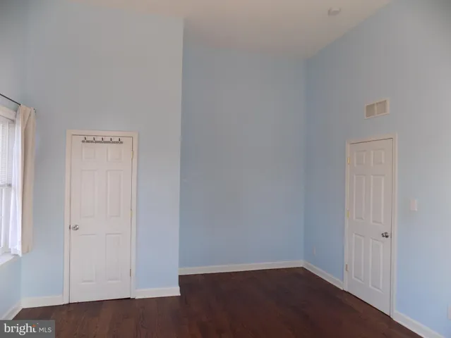an empty room with wooden floor and closet