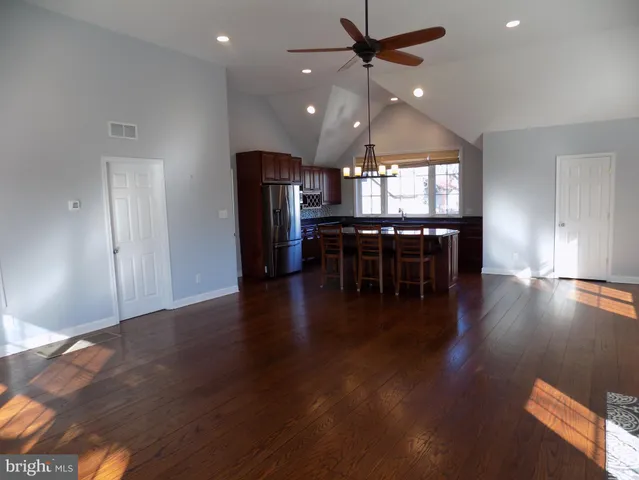 an open kitchen with dining table stainless steel appliances and wooden floor