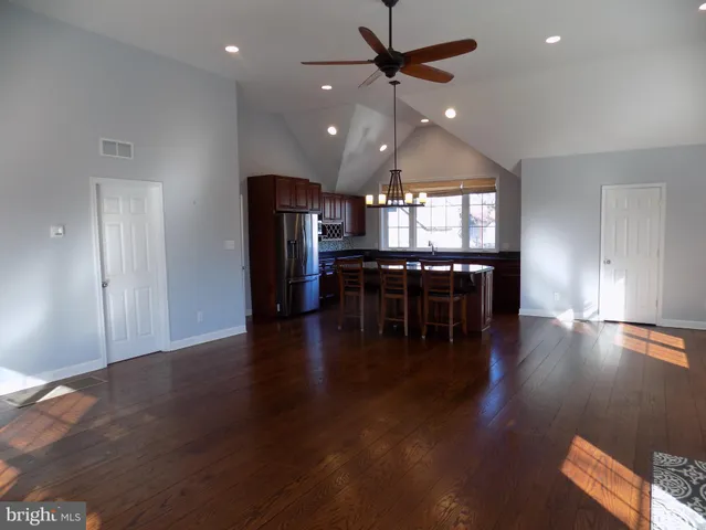 an open kitchen with wooden floor and chandelier