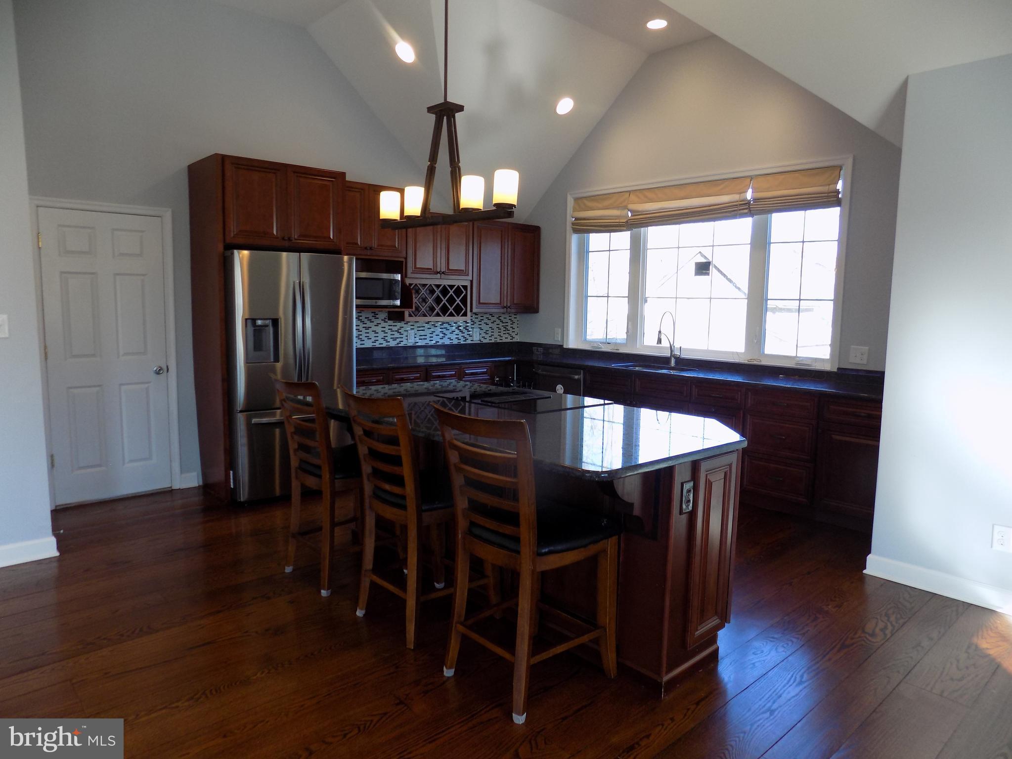 53 Sunset Avenue, Unit 3 Chalfont, PA 18914 - Photo 7 of 20 a kitchen with stainless steel appliances granite countertop a table chairs stove and refrigerator