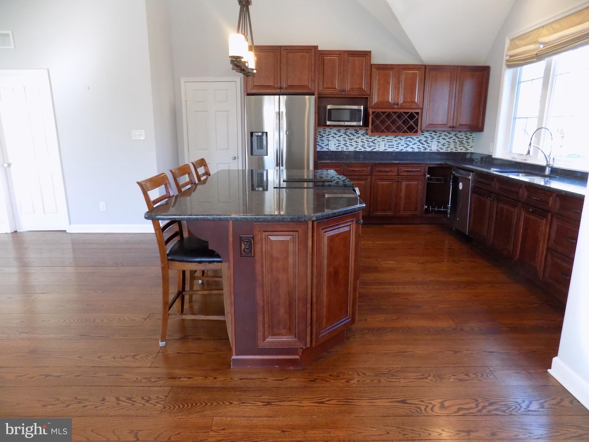 53 Sunset Avenue, Unit 3 Chalfont, PA 18914 - Photo 8 of 20 a kitchen with stainless steel appliances kitchen island granite countertop a table chairs in it and wooden floors