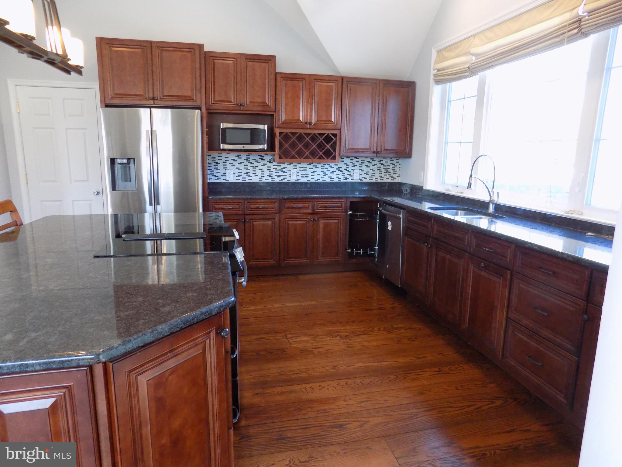 53 Sunset Avenue, Unit 3 Chalfont, PA 18914 - Photo 9 of 20 a kitchen with stainless steel appliances granite countertop a refrigerator a sink dishwasher a stove with wooden cabinets and floor