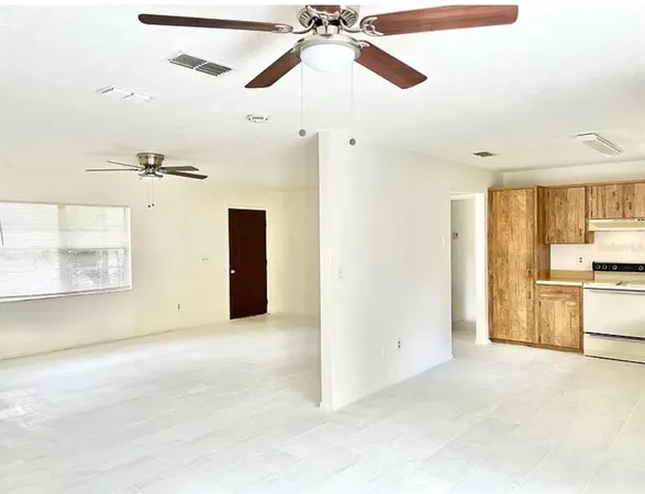 a view of a room with a ceiling fan and a window