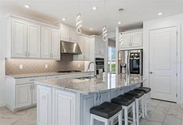 a kitchen with kitchen island a counter top space appliances and cabinets