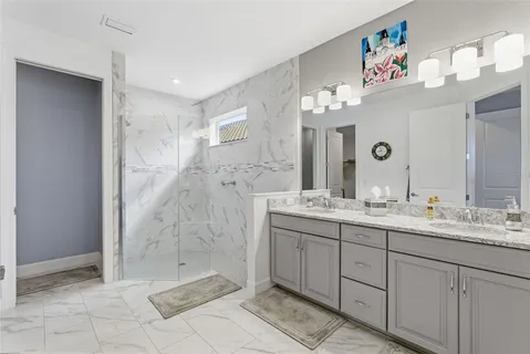 a bathroom with a double vanity sink mirror and shower