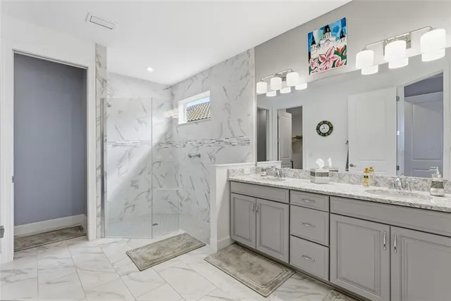 a bathroom with a double vanity sink mirror and shower