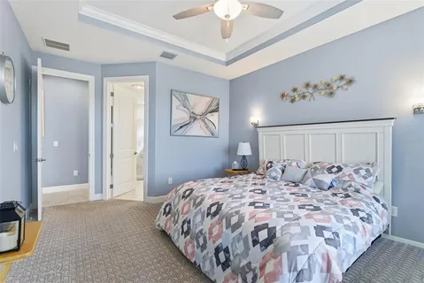 a bedroom with a large bed and a chandelier