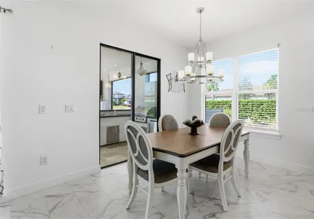 a dining room with furniture a chandelier and window