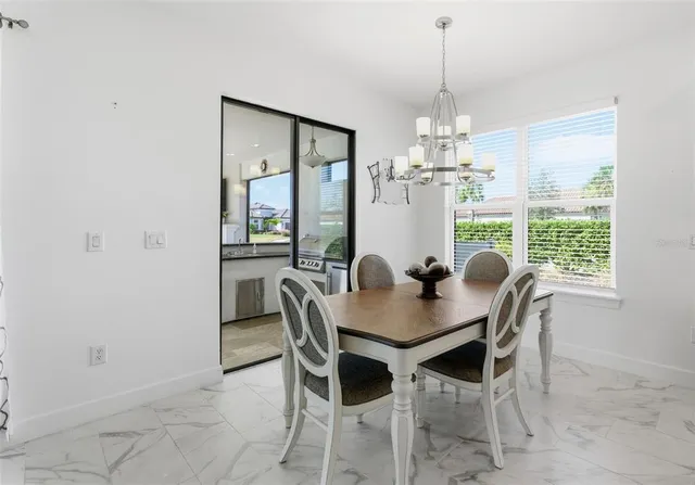 a dining room with furniture a chandelier and window