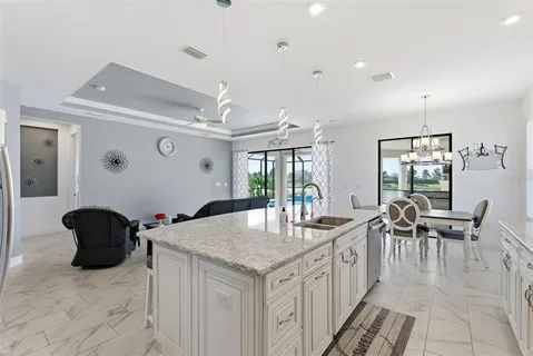 a kitchen with granite countertop a sink a counter top space and living room view