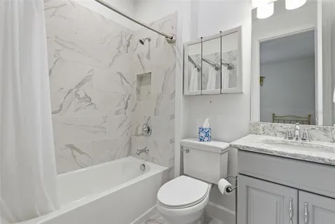 a bathroom with a sink toilet vanity and shower