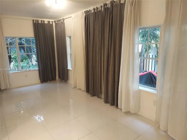 a view of a bedroom with windows and closet