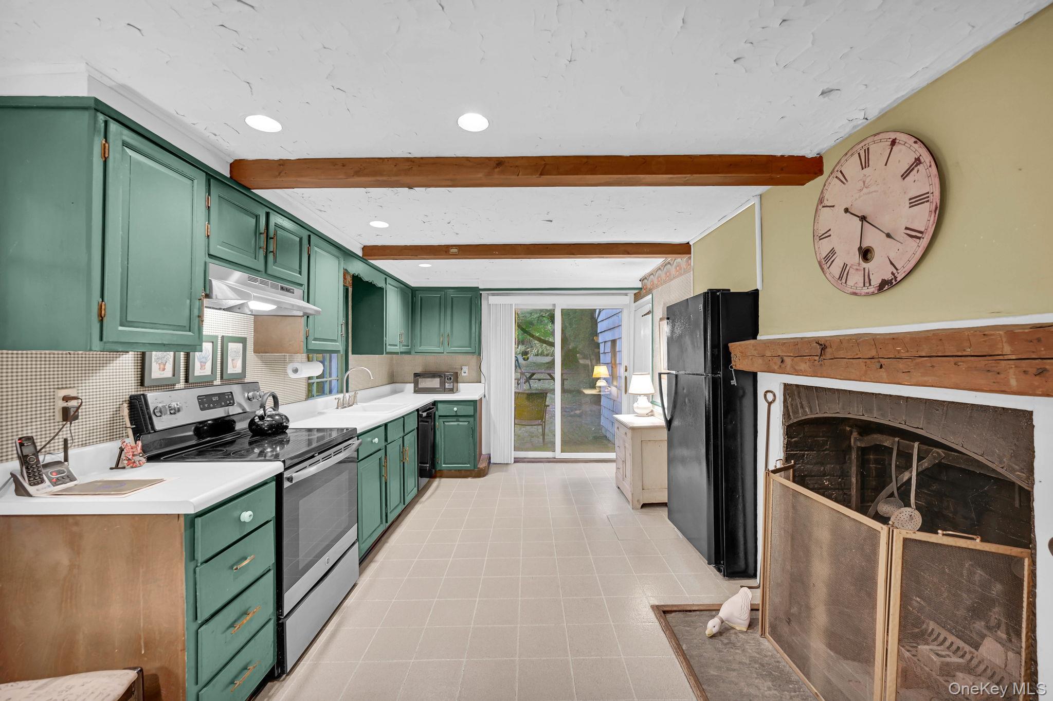 33 Ryder Road Ossining, NY 10562 - Photo 17 of 48 Kitchen with green cabinets, electric stove, beam ceiling, light countertops, and freestanding refrigerator