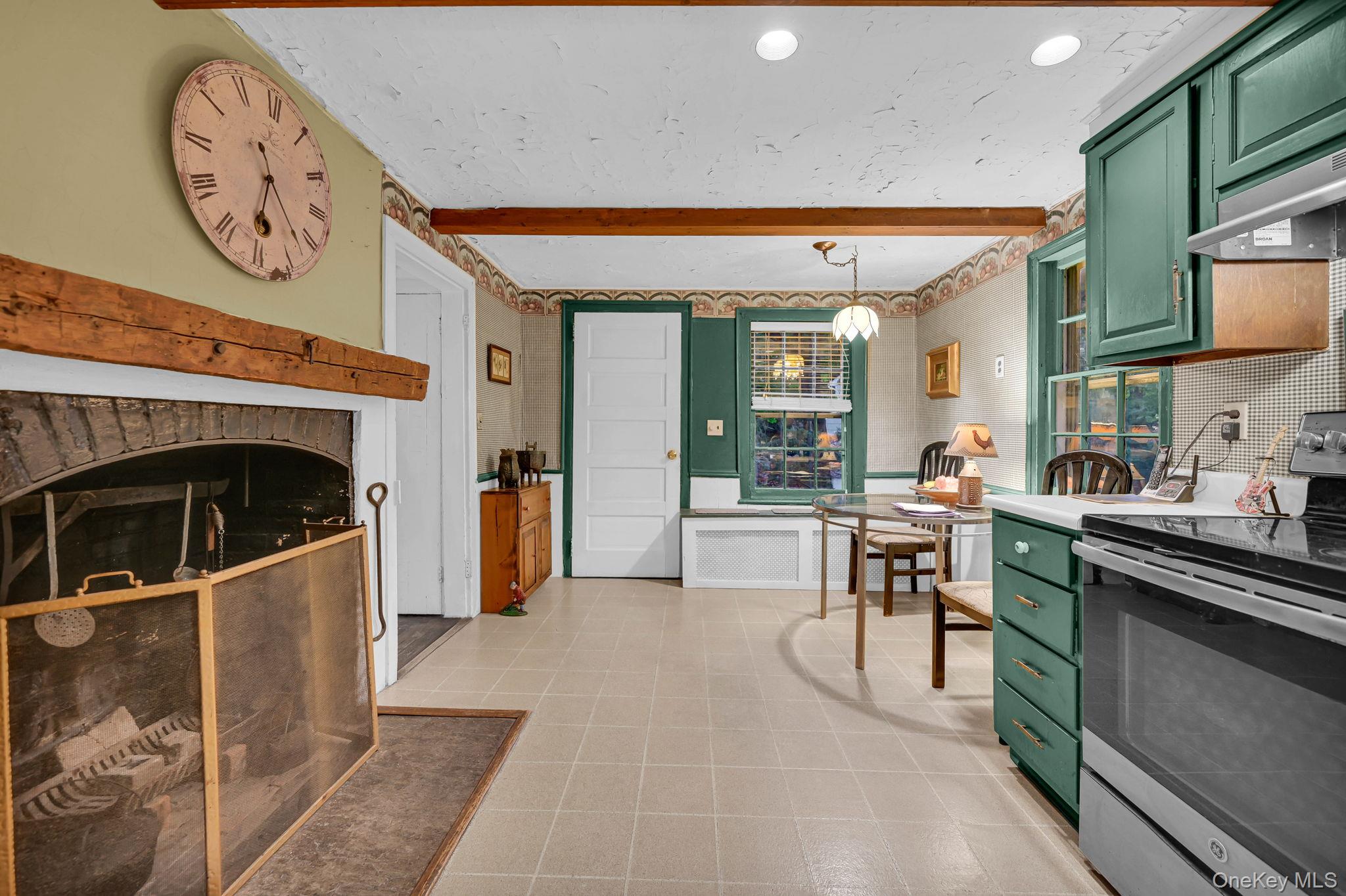 33 Ryder Road Ossining, NY 10562 - Photo 20 of 48 Kitchen featuring green cabinetry, stainless steel electric range, light countertops, beamed ceiling, and tasteful backsplash