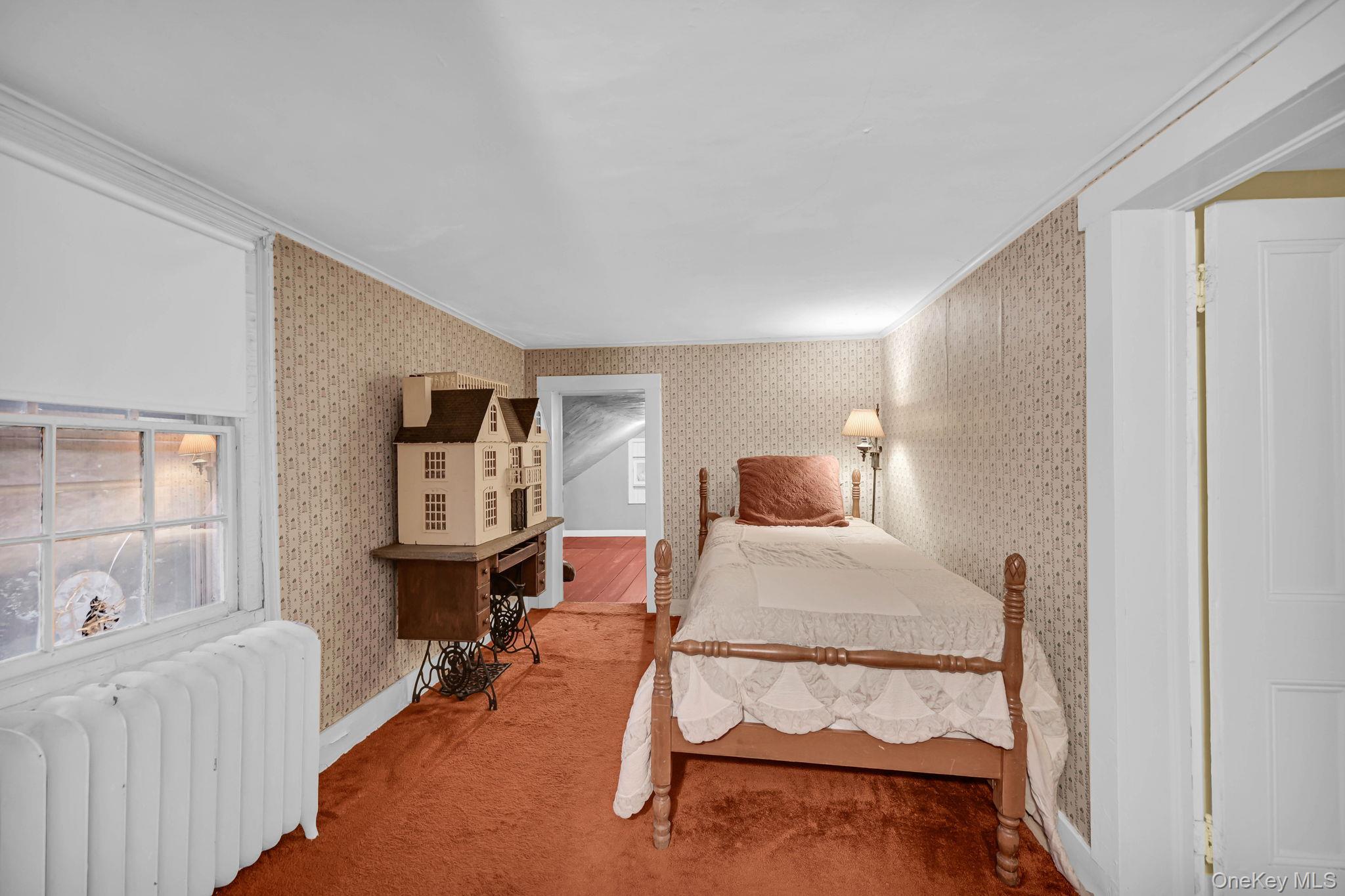 33 Ryder Road Ossining, NY 10562 - Photo 25 of 48 Bedroom with radiator heating unit, crown molding, wallpapered walls, and carpet flooring