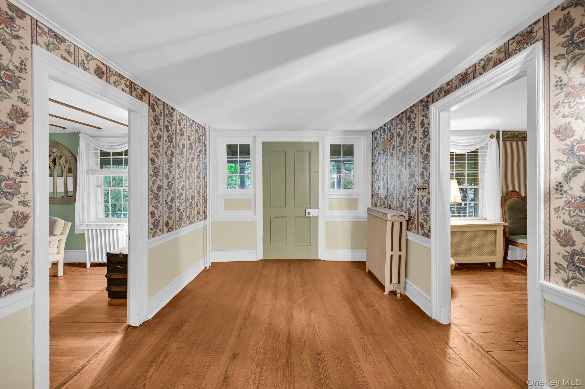 33 Ryder Road Ossining, NY 10562 - Photo 3 of 48 Corridor featuring wallpapered walls, healthy amount of natural light, light wood-type flooring, and radiator heating unit