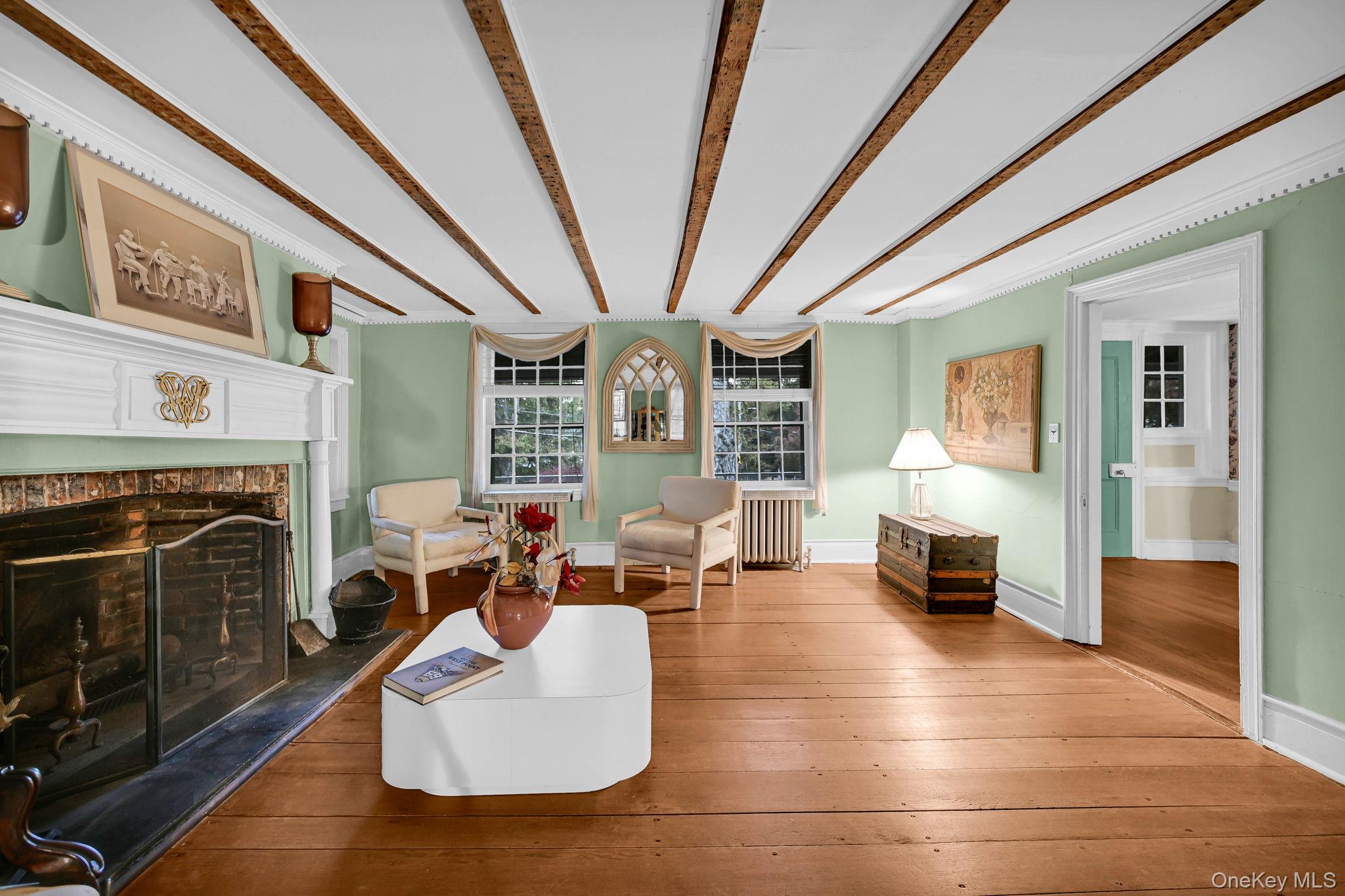 33 Ryder Road Ossining, NY 10562 - Photo 5 of 48 Sitting room featuring wood-type flooring, radiator, beamed ceiling, and a fireplace with raised hearth