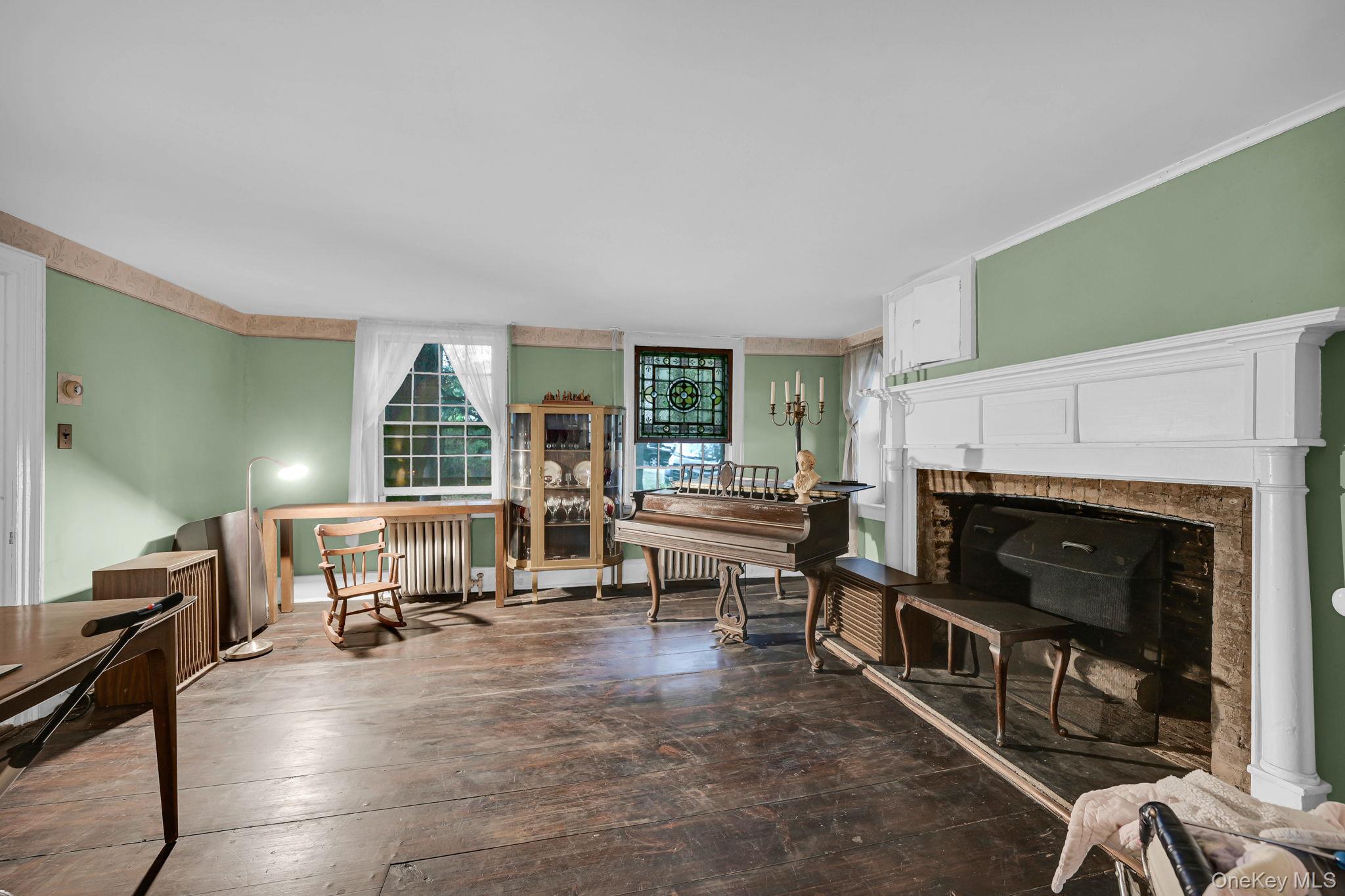 33 Ryder Road Ossining, NY 10562 - Photo 6 of 48 Living room featuring hardwood / wood-style flooring, a fireplace, ornamental molding, and radiator heating unit