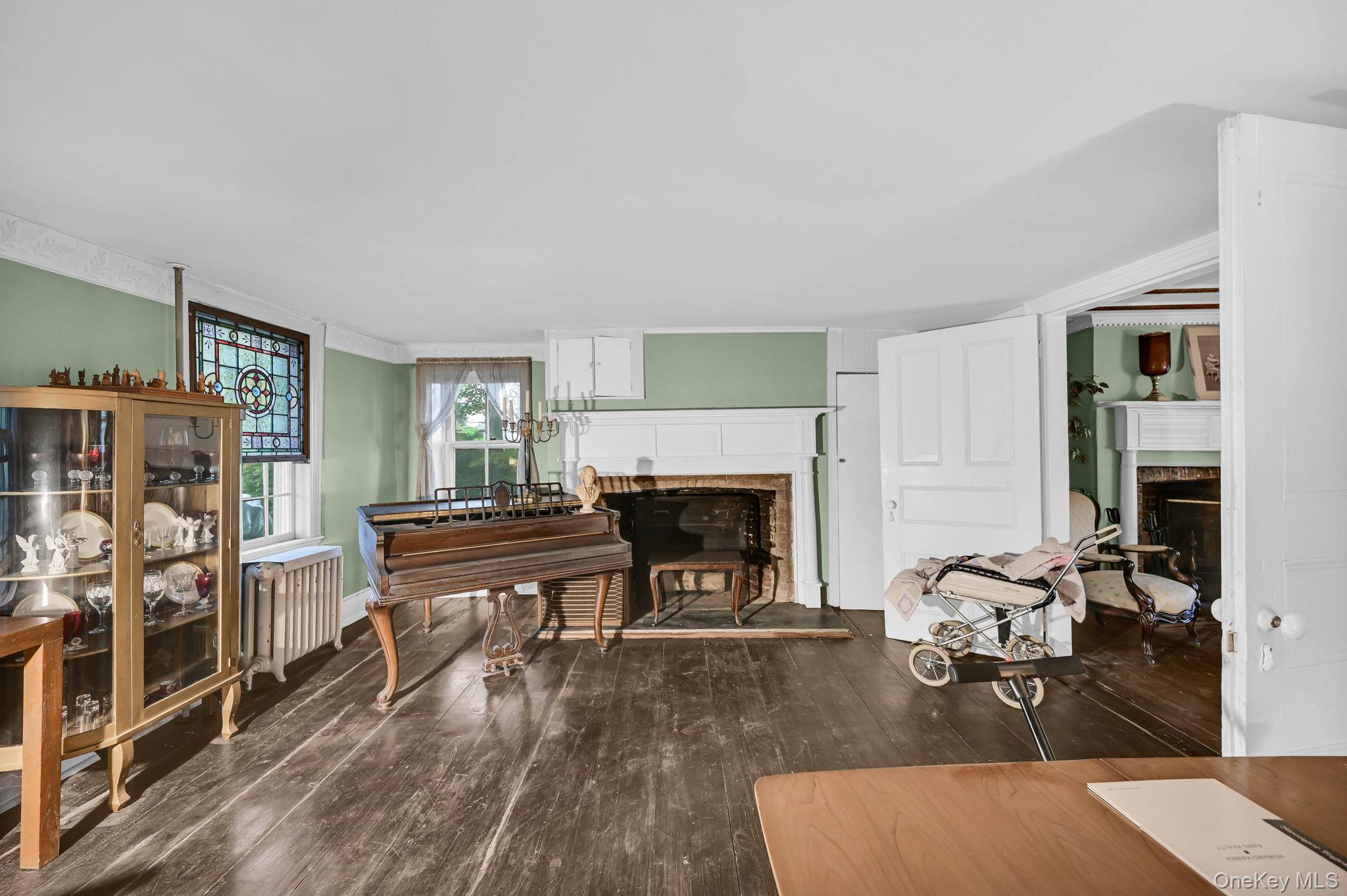 33 Ryder Road Ossining, NY 10562 - Photo 7 of 48 Sitting room featuring a fireplace with raised hearth, dark wood-type flooring, and radiator