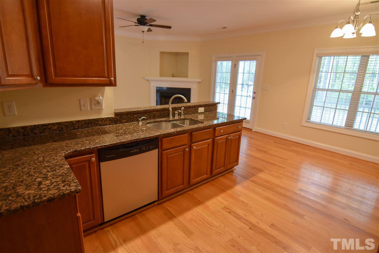 292 Ned Moore Road Timberlake, NC 27583 - Photo 8 of 25 a kitchen with stainless steel appliances granite countertop a sink a stove cabinets and wooden floor