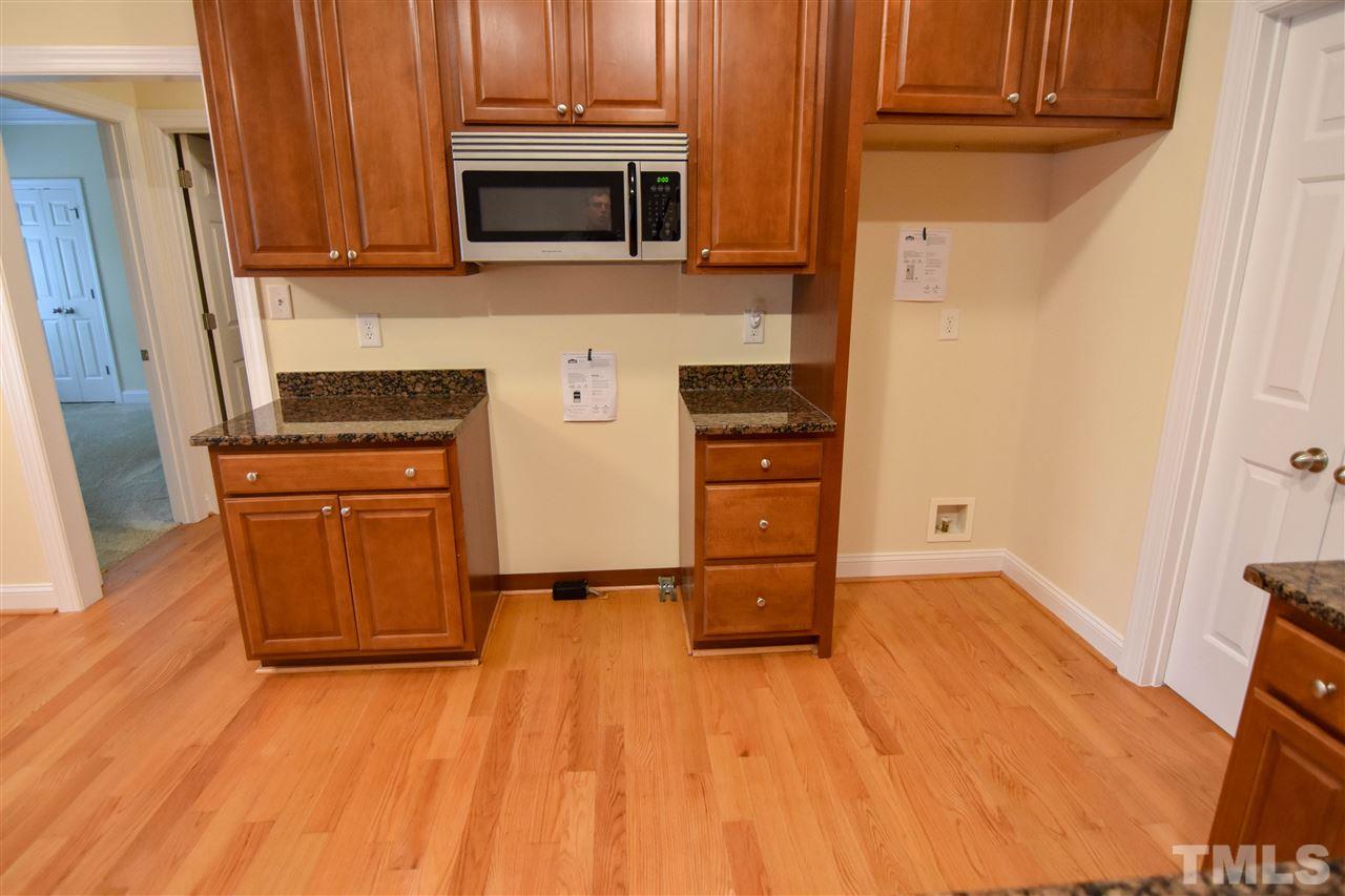 292 Ned Moore Road Timberlake, NC 27583 - Photo 9 of 25 a kitchen with granite countertop wooden cabinets and stainless steel appliances