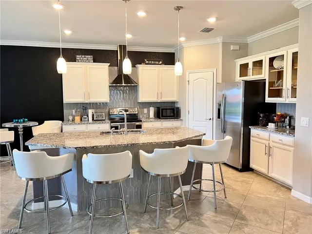 a kitchen with stainless steel appliances kitchen island granite countertop a sink and cabinets