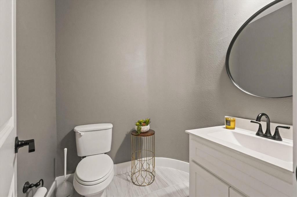 1714 Highwood Road Forney, TX 75126 - Photo 26 of 30 a white toilet sitting next to a bathroom sink