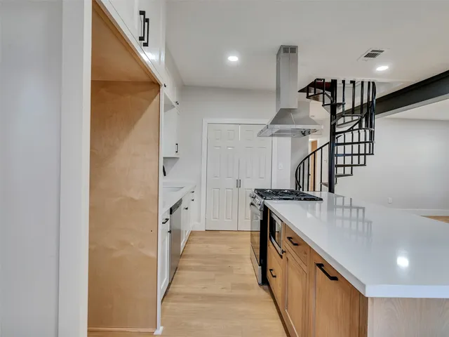 a kitchen with granite countertop a refrigerator a sink and a stove top oven