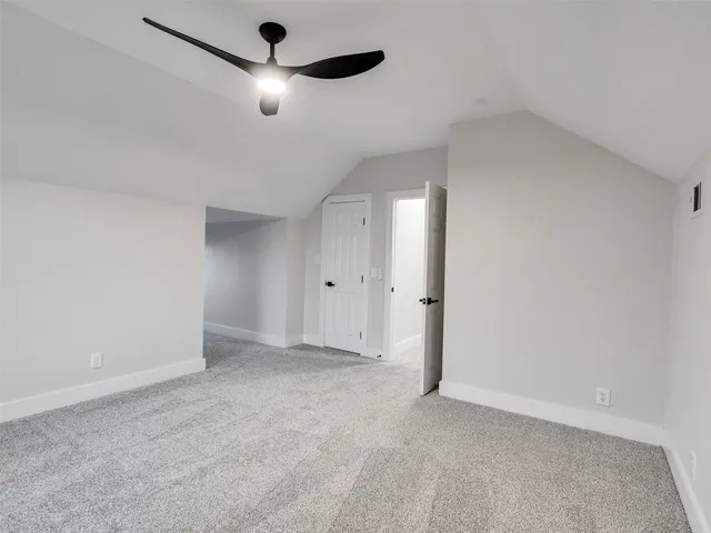 an empty room with ceiling fan and window