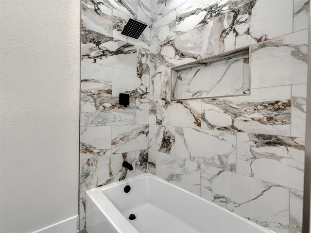 a bathroom with a bathtub and shower