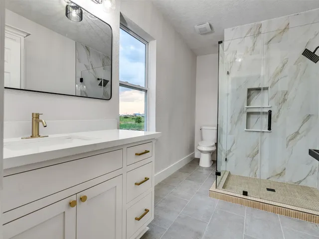 a spacious bathroom with a shower sink and mirror