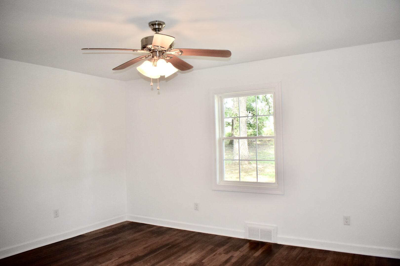 13753 West Gretna Road Sandy Level, VA 24161 - Photo 49 of 99 an empty room with wooden floor ceiling fan and window
