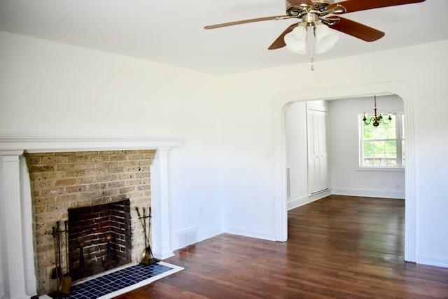 13753 West Gretna Road Sandy Level, VA 24161 - Photo 70 of 99 an empty room with wooden floor a ceiling fan a fireplace and windows