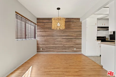 a view of empty room with window and wooden floor