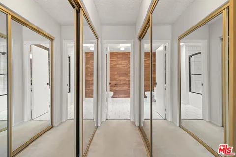 a view of a hallway with wooden shelves