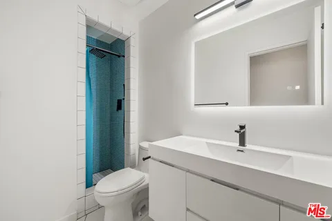 a bathroom with a sink toilet and mirror