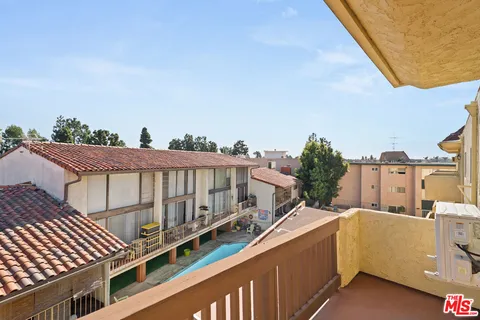 a view of a balcony with wooden floor and fence