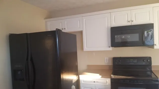 a kitchen with granite countertop white cabinets and stainless steel appliances