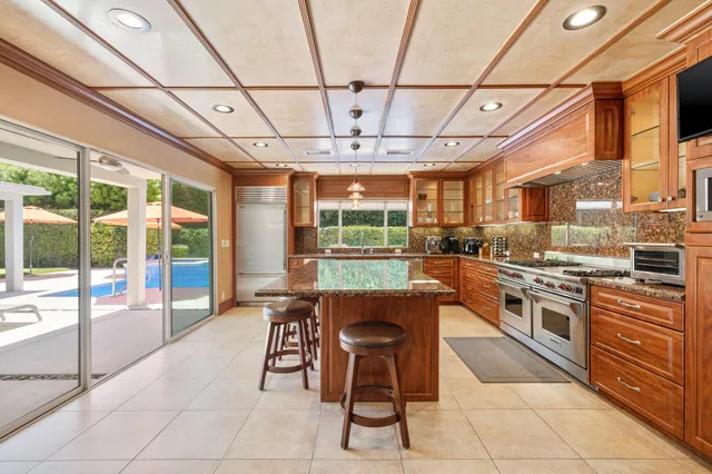 a kitchen with stainless steel appliances granite countertop a stove a sink dishwasher a dining table and chairs with floor