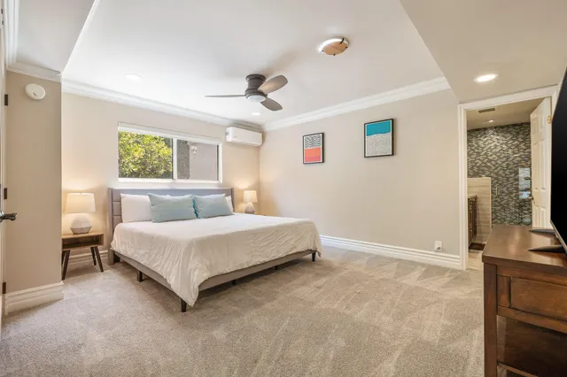 a spacious bedroom with a bed and a flat screen tv