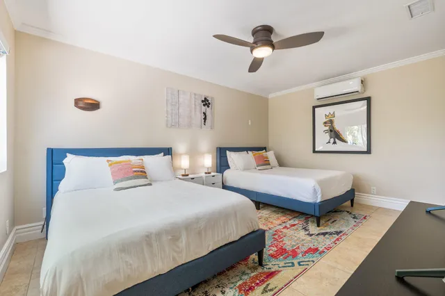 a bedroom with two beds and painting on the wall